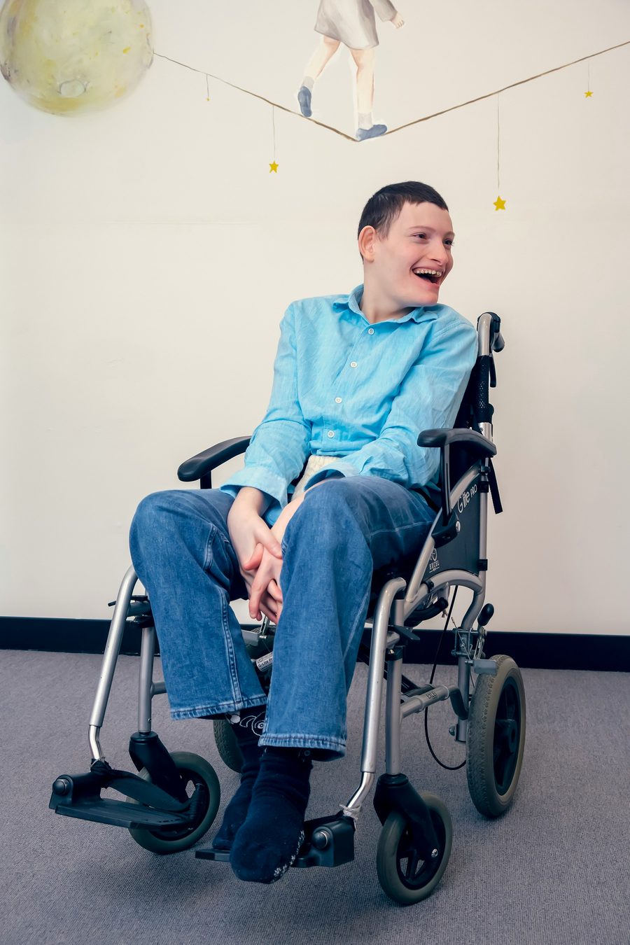 A young man in a wheelchair laughing during an activity session.